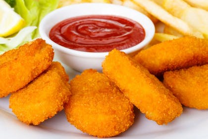 A plate of chicken nuggets with ketchup