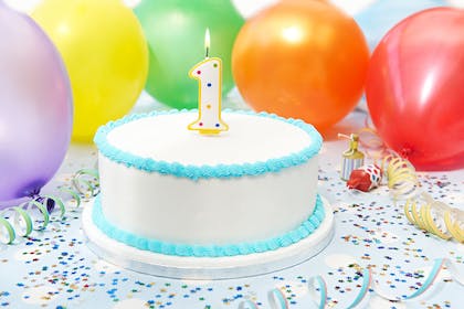 1-year-old birthday cake with balloons in the background