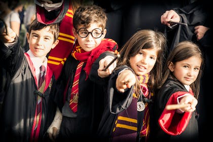 Group of kids dressed in Hogwarts Gryffindor robes for Harry Potter party costume